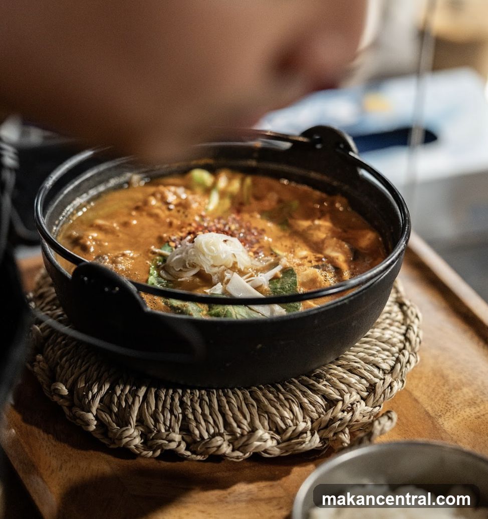 Food dish in black pot on woven mat