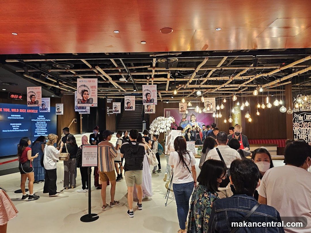Interior of a venue with crowd and promotional signage