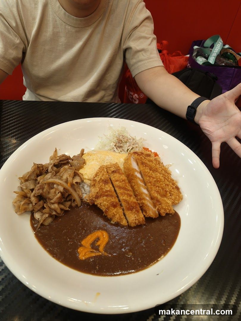 Person at dining table with curry rice dish