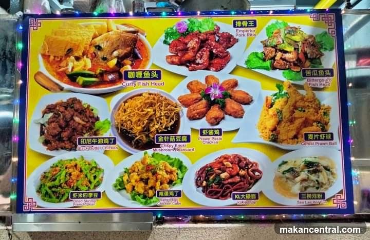 Colorful menu board with ten dishes displayed in white bowls on a yellow background, each labeled with Chinese characters and English translations. The board is framed with decorative blue border and string lights. Dishes include curry fish head, emperor pork ribs, bittergourd fish head, fried chicken wings, crispy enoki mushroom, KI noodles, etc.