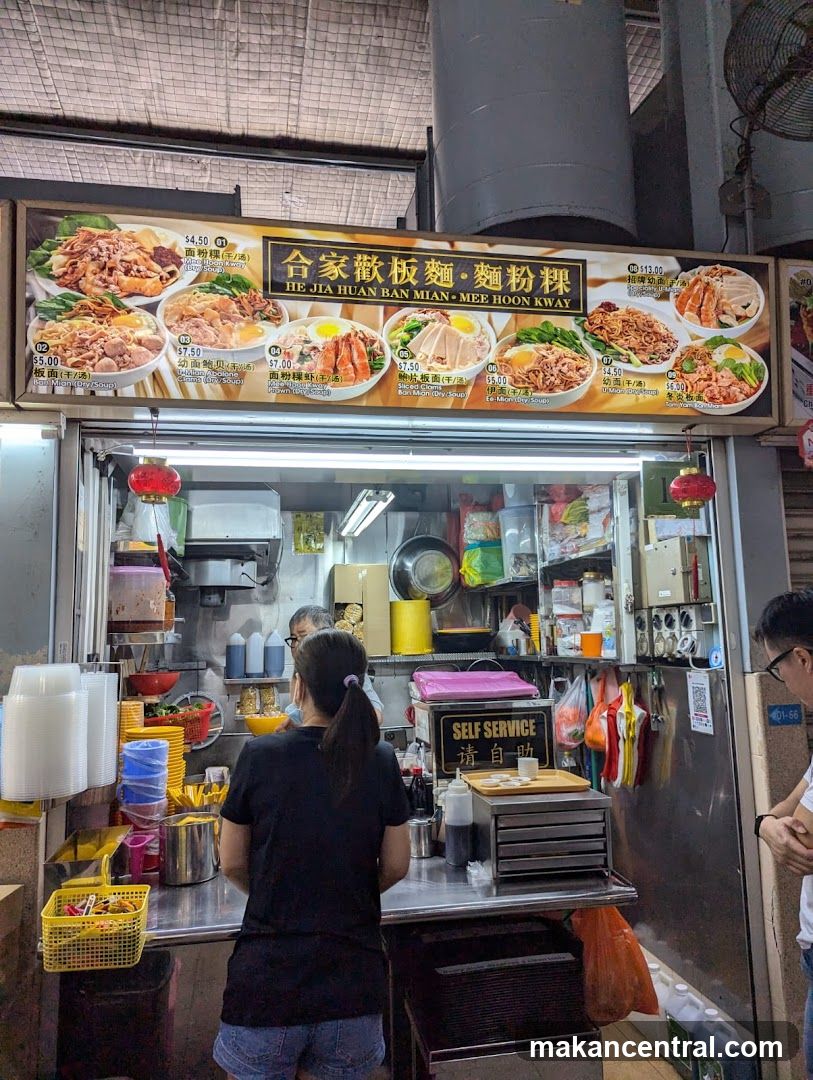 Food stall interior with customers and signage