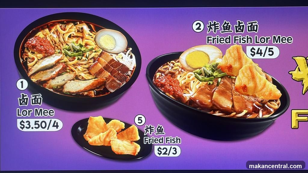 Digital menu board displaying two noodle dishes with prices in USD. Items include Lor Mee (with various toppings), Fried Fish Lor Mee (with fried fish topping), and Fried Fish as a side item.