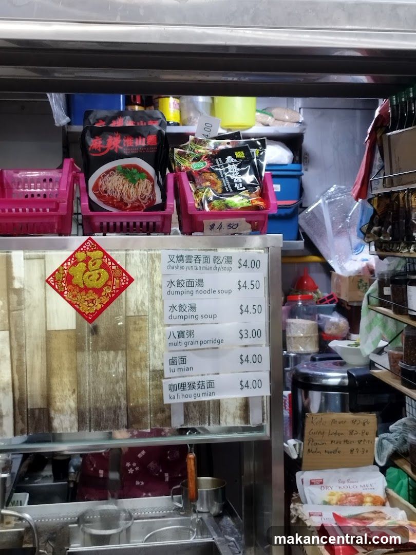 Food stall interior with prepared ingredients and pricing display
