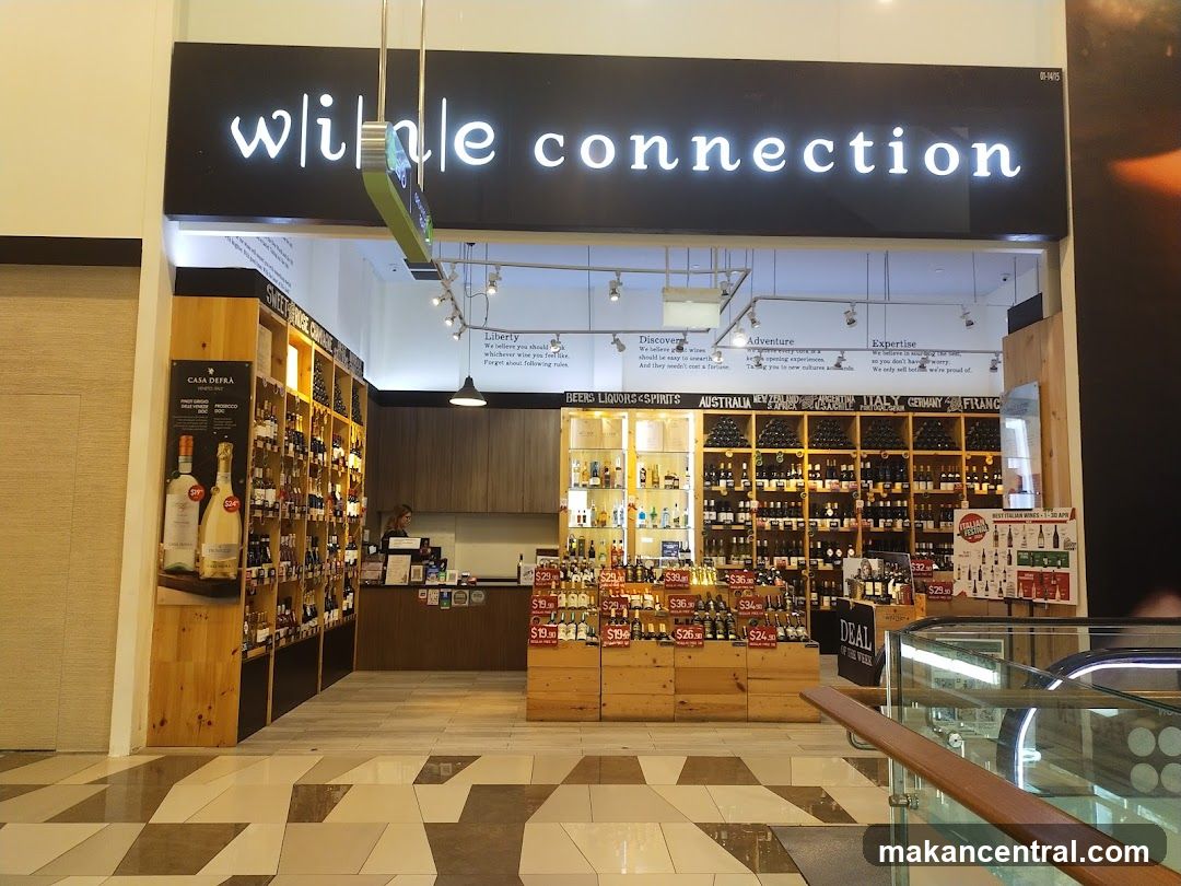 Store entrance with illuminated sign reading 'wine connection' above the doorway. Interior shows wooden shelving stocked with wine bottles, display cases, and a counter area. Promotional signs and price tags are visible inside but not considered shop_front.