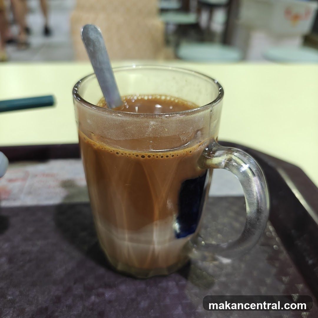 Cup of beverage in a glass mug with spoon