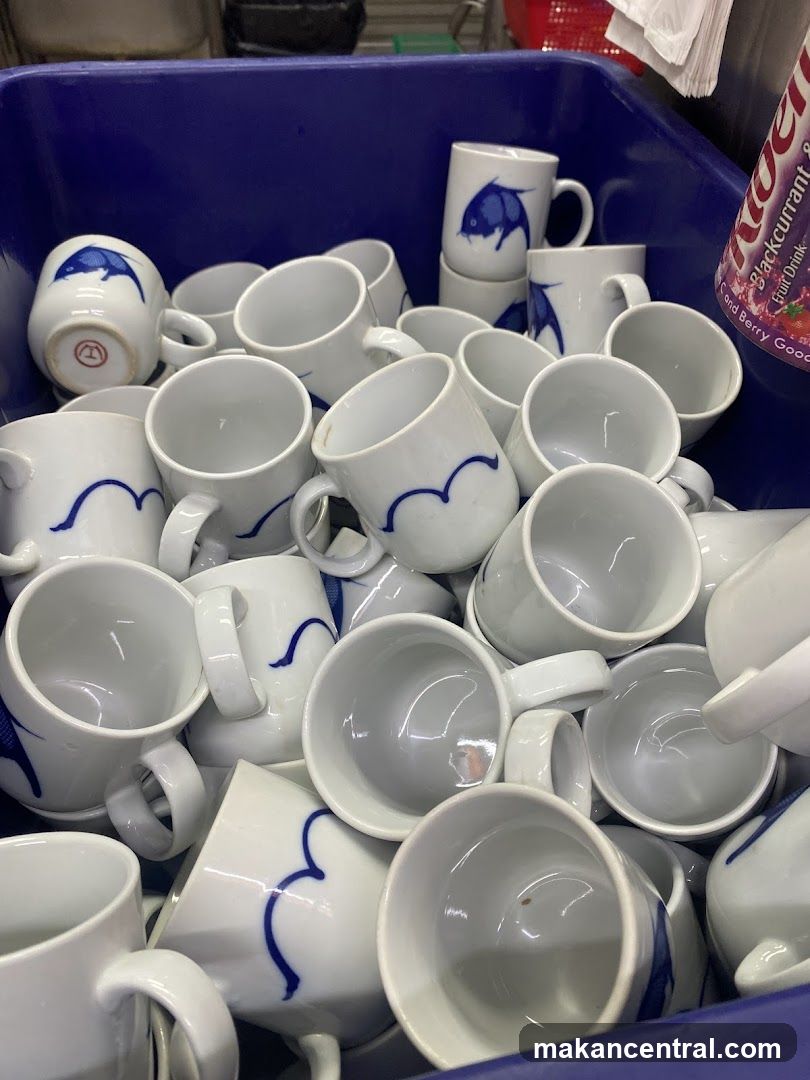 Ceramic mugs in a blue bin