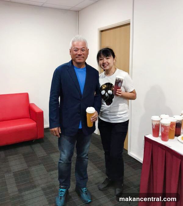 Two people posing indoors with beverages
