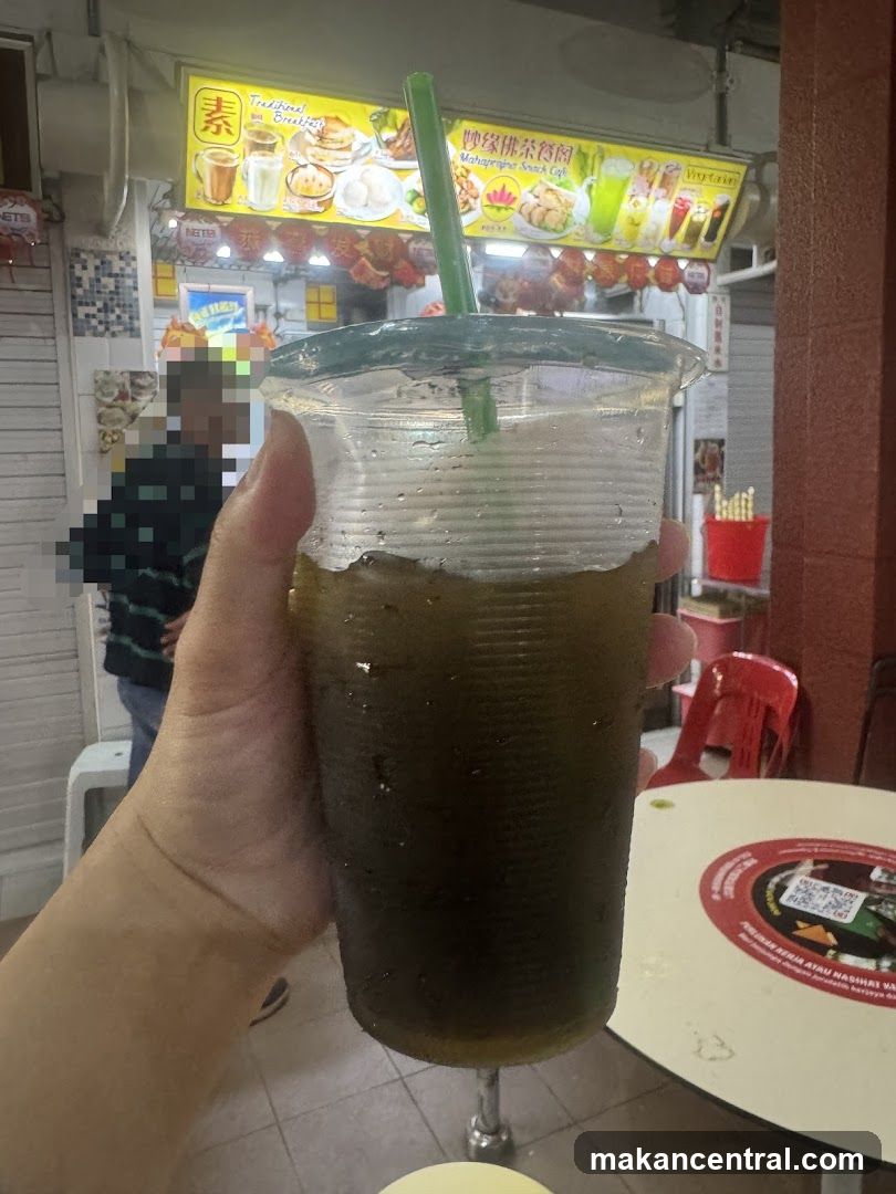 Hand holding iced beverage in food court