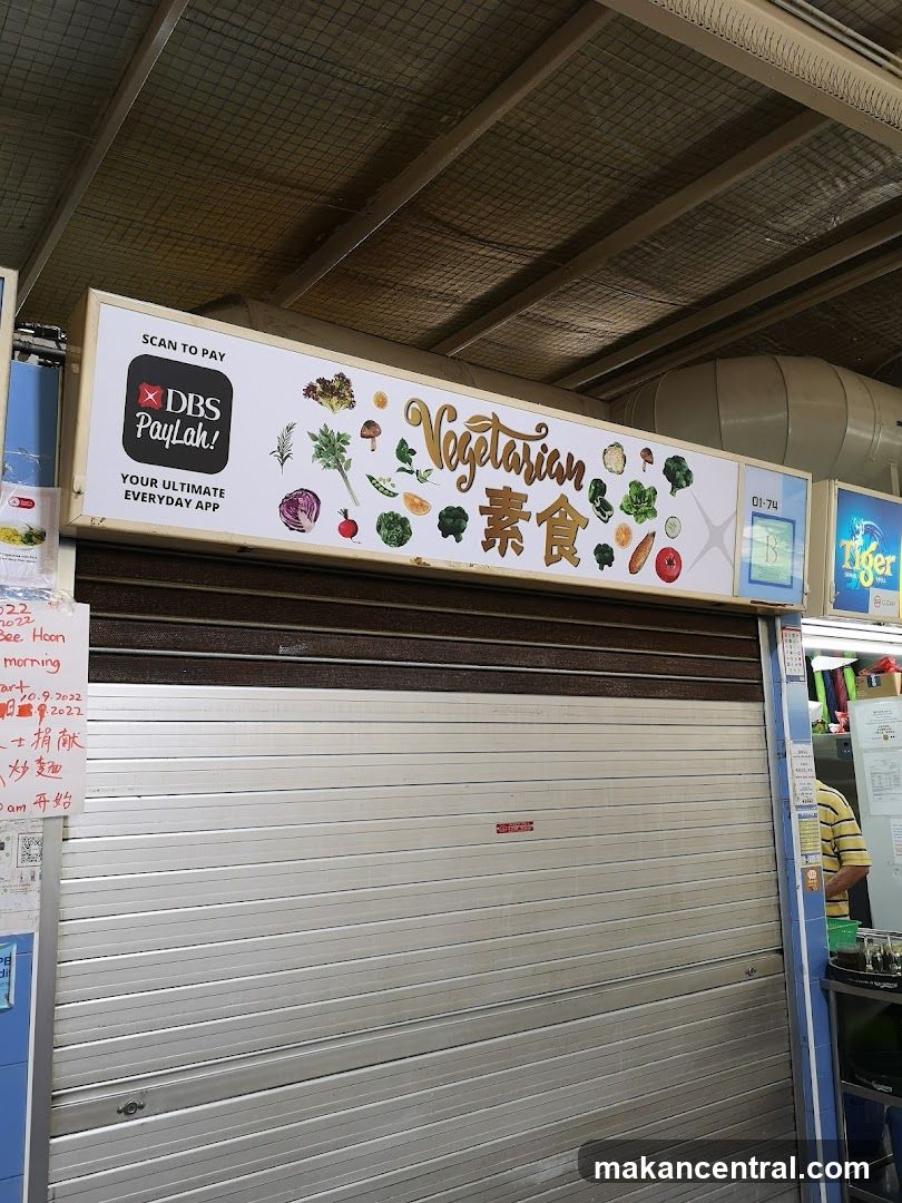 Closed shuttered storefront with sign above reading 'Vegetarian 素食' featuring vegetable illustrations and DBS PayLah! payment logo. Sign includes 'SCAN TO PAY' and 'YOUR ULTIMATE EVERYDAY APP'. Shop number 01-74 is visible on the right side of the sign. A partial view of adjacent stall with 'Tiger' branding is seen to the right.