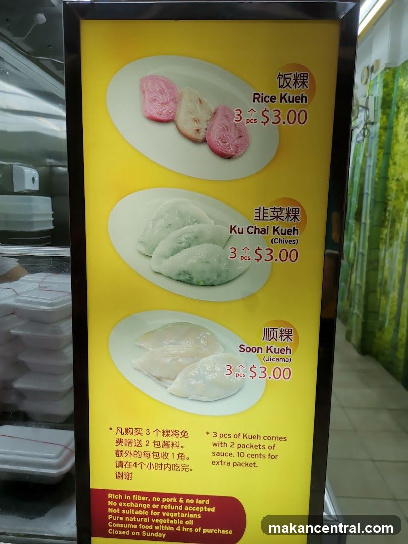 Yellow menu board displaying three types of kueh: Rice Kueh (3 pcs $3.00), Ku Chai Kueh (Chives) (3 pcs $3.00), and Soon Kueh (Jicama) (3 pcs $3.00). Includes bilingual text in Chinese and English with pricing, promotional details on sauce inclusion, and notes about fiber content, vegetarian suitability, and purchase restrictions.