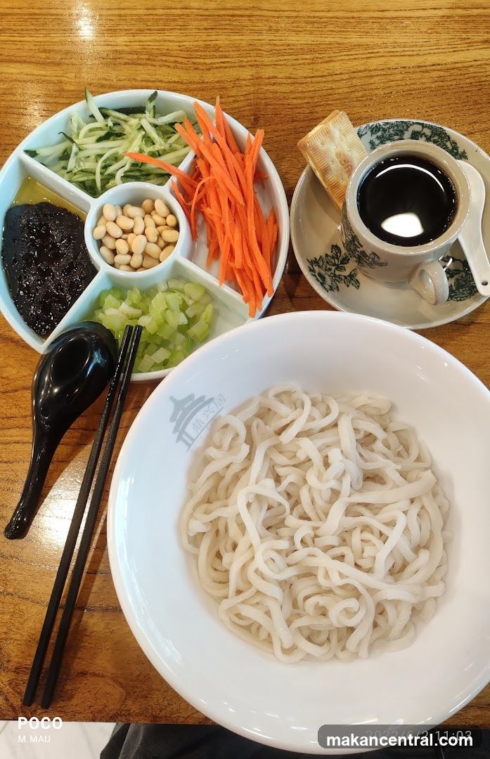 Noodle dish with condiments and tea