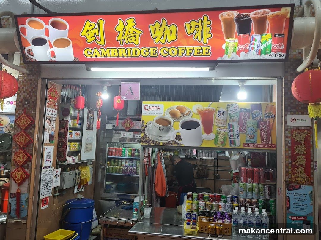 Exterior storefront with bright red sign featuring Chinese characters '剑桥咖啡' and English name 'CAMBRIDGE COFFEE'. Sign includes images of coffee cups and soda cans. Red lanterns hang on either side. Interior shows a self-service area, refrigerated drinks, and staff working behind counter. Visible signage includes 'CUPPA', 'SELF-SERVICE', and 'CLEAN' stickers.