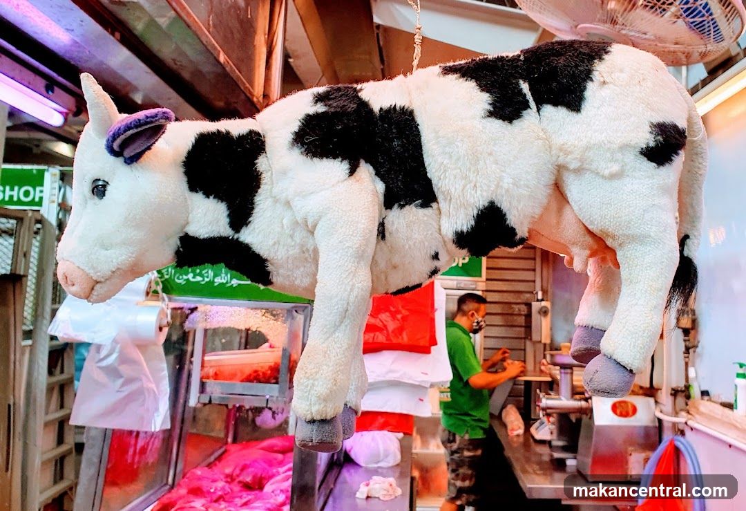 Cow plush toy in meat market interior