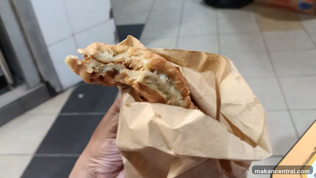 Hand holding food wrapped in paper
