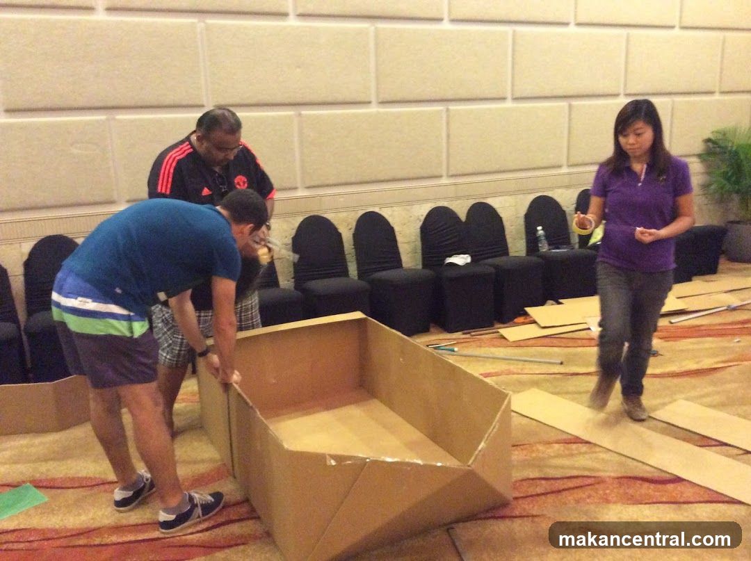 People assembling cardboard structure