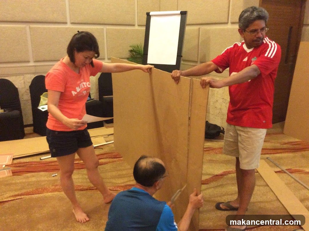 People assembling cardboard structure