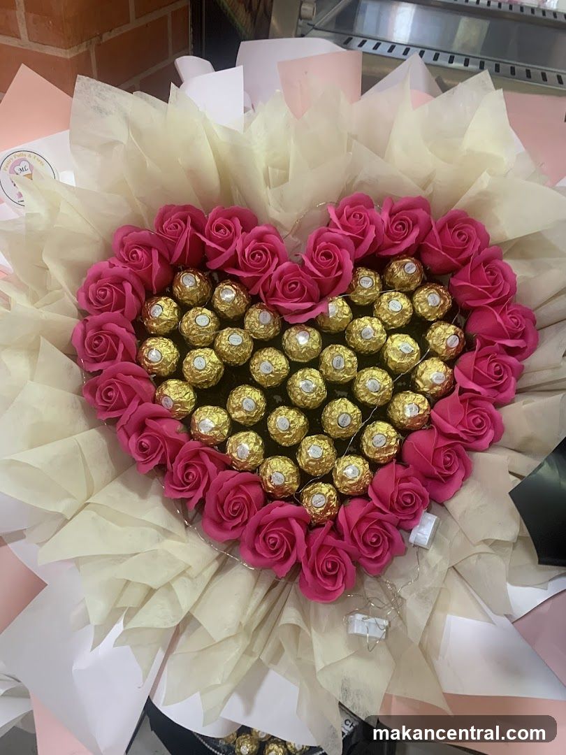 Heart-shaped arrangement of pink roses and Ferrero Rocher chocolates