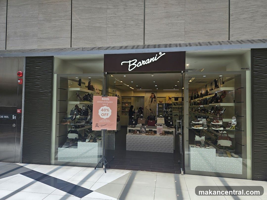 The exterior of a Barani shoe and handbag store. The store has a large glass facade displaying shoes and handbags on shelves. A sign in the window advertises a 40th anniversary sale with 40% off.
