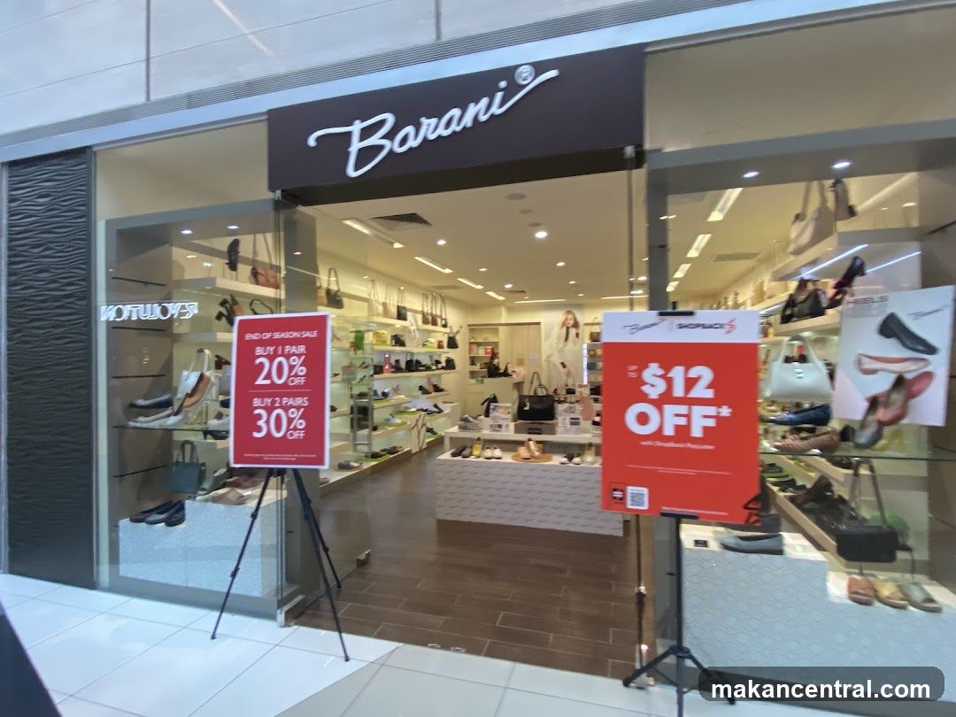 The exterior of a shoe store with the brand name "Barani" visible above the entrance. The store displays various shoes and handbags inside. Two promotional signs are placed outside the entrance: one advertising an "END OF SEASON SALE" with discounts of 20% off for one pair and 30% off for two pairs, and another offering "$12 OFF" with ShopBack.