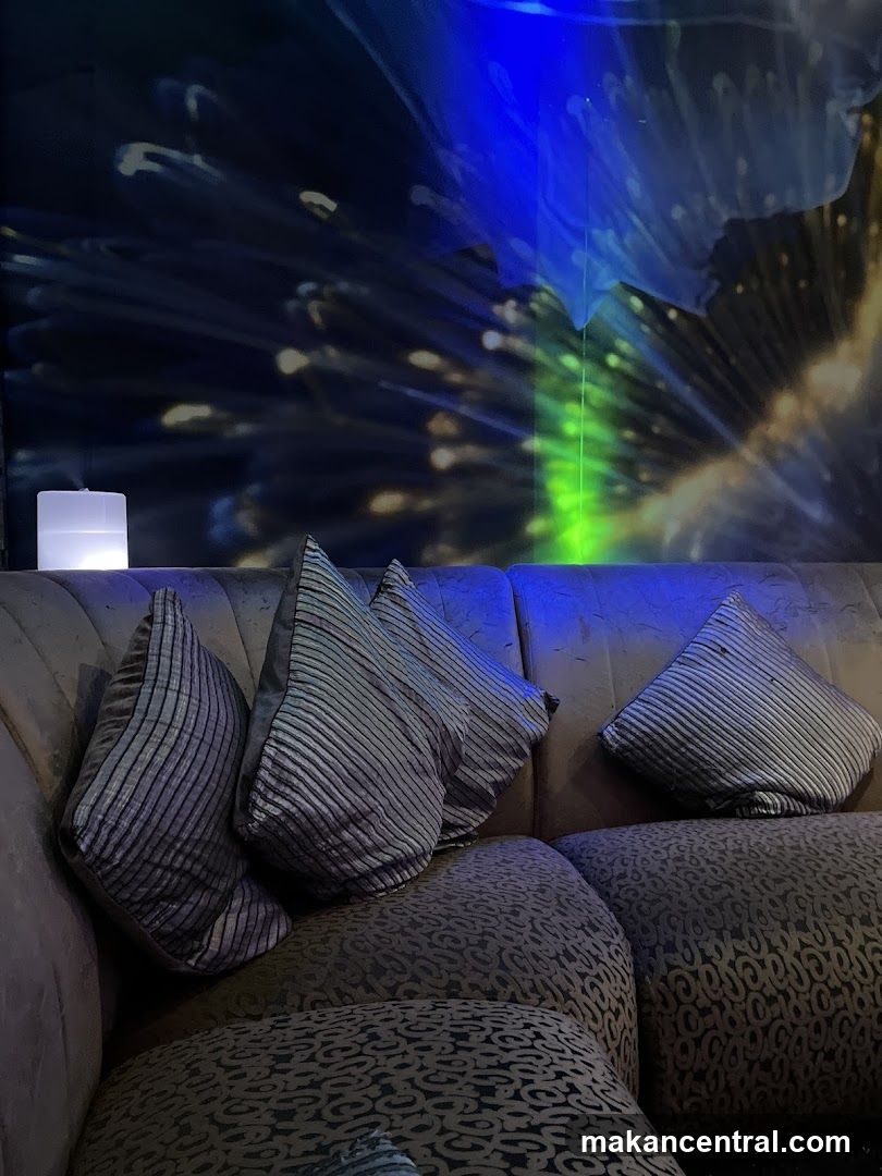 Sofa with decorative pillows and illuminated wall art