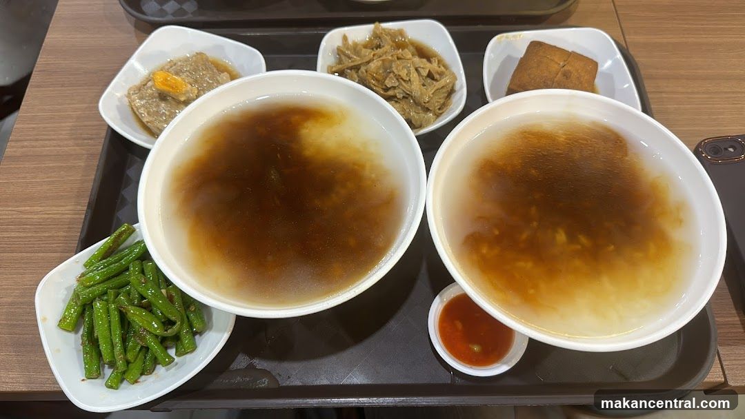 Two bowls of soup with side dishes