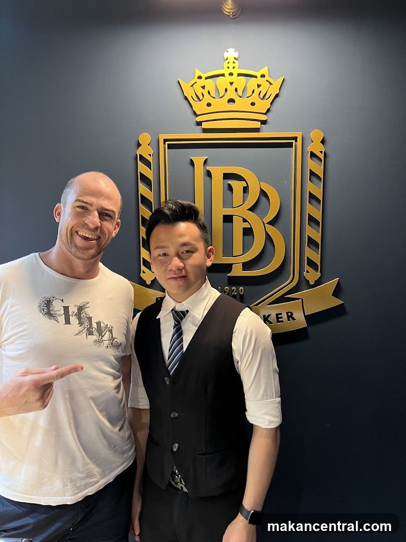Two men posing in front of a logo