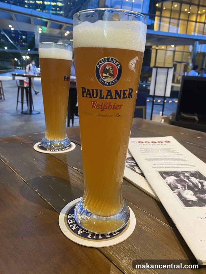 Two glasses of Paulaner Weissbier on a wooden table