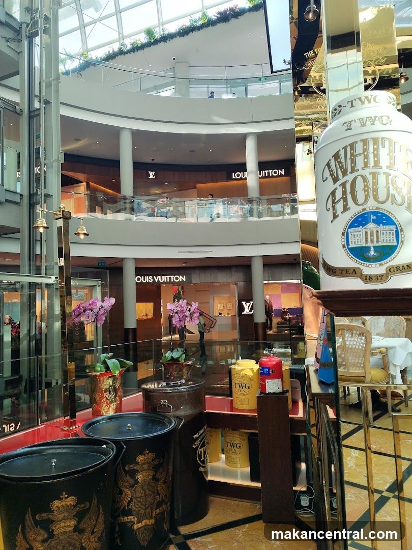 Interior of a multi-level shopping mall with Louis Vuitton store visible