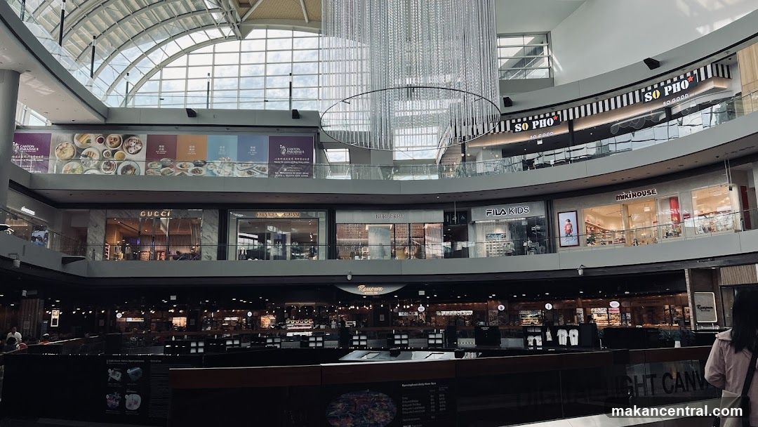 Indoor shopping mall with various stores and a large chandelier