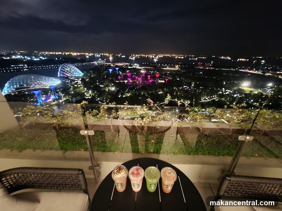 Drinks on a balcony overlooking a city at night