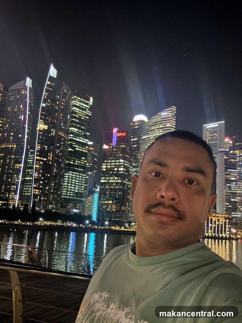 Man taking a selfie at night with city skyline in background