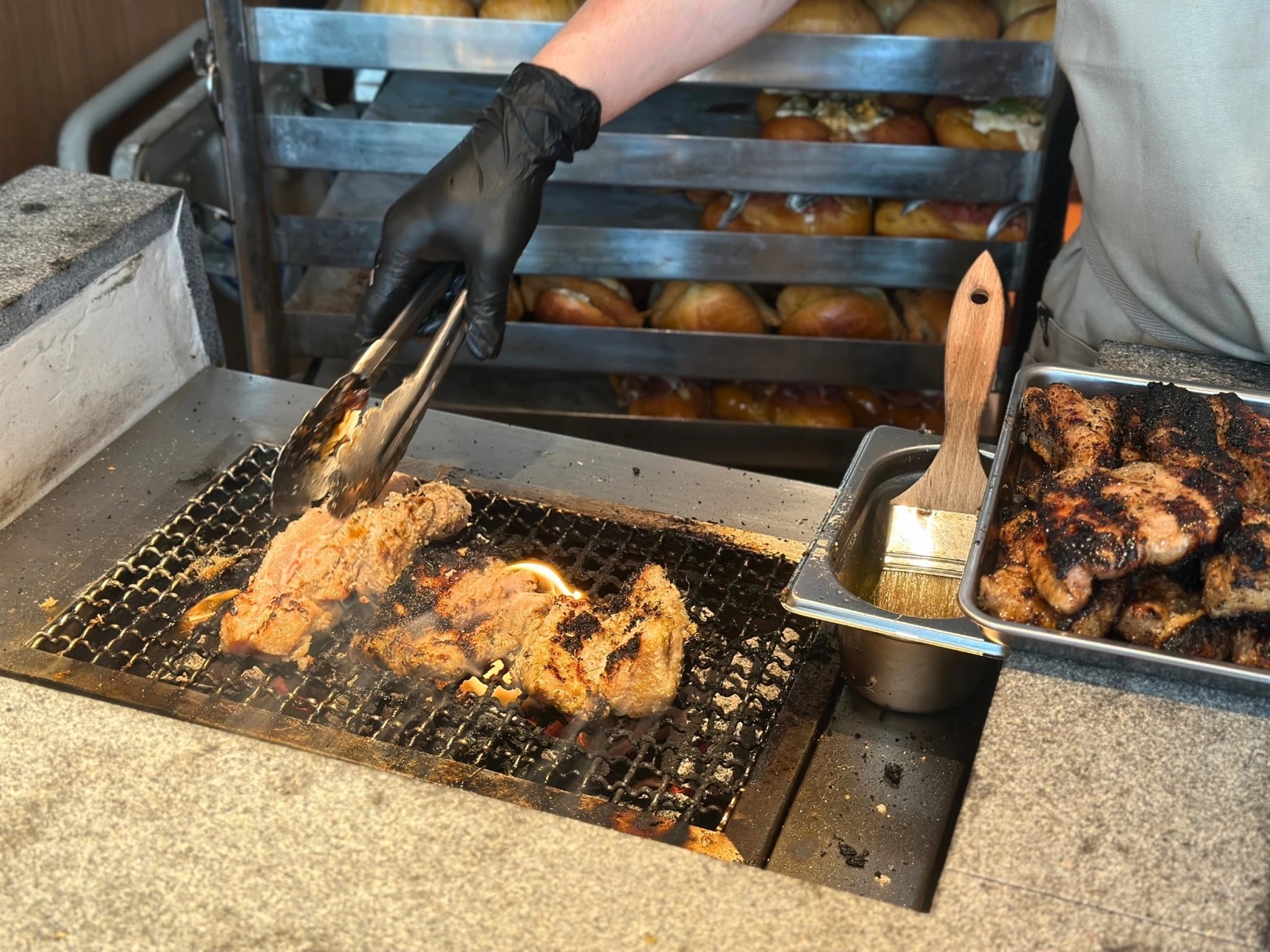 Binchotan grill at Cloudmills Orchard with pork being turned for savoury bakes