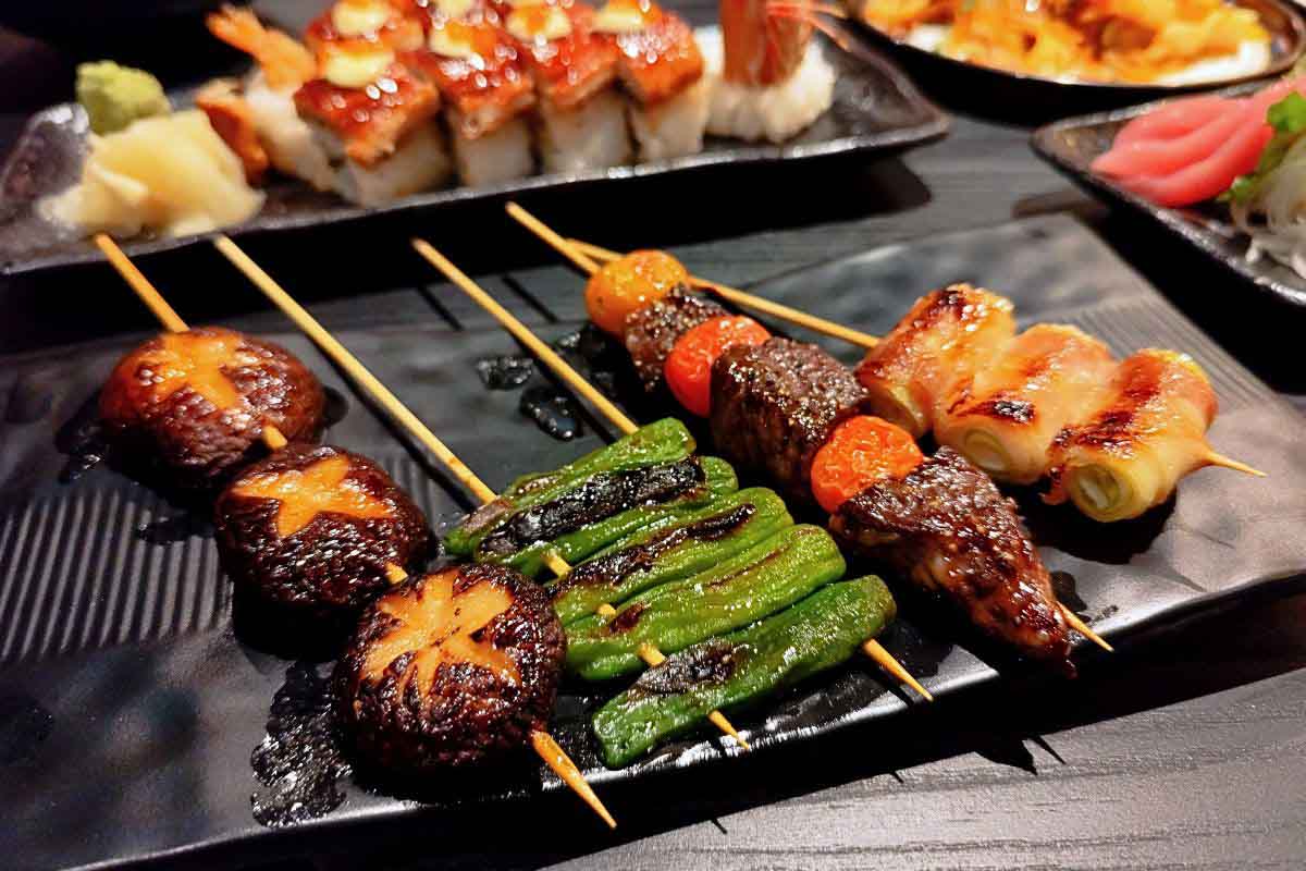 Assorted binchotan charcoal-grilled yakitori skewers at Kokoro Izakaya, including pork-wrapped leek, wagyu and shiitake mushroom